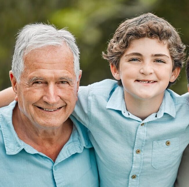 Three generations of men embracing affectionately.