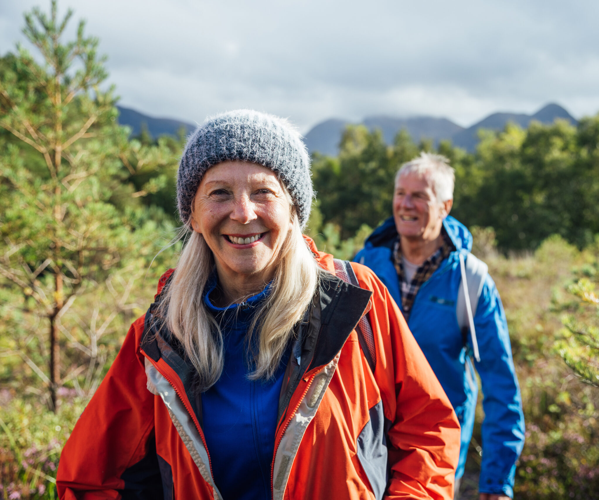 Elderly couple hiking together in the woods.