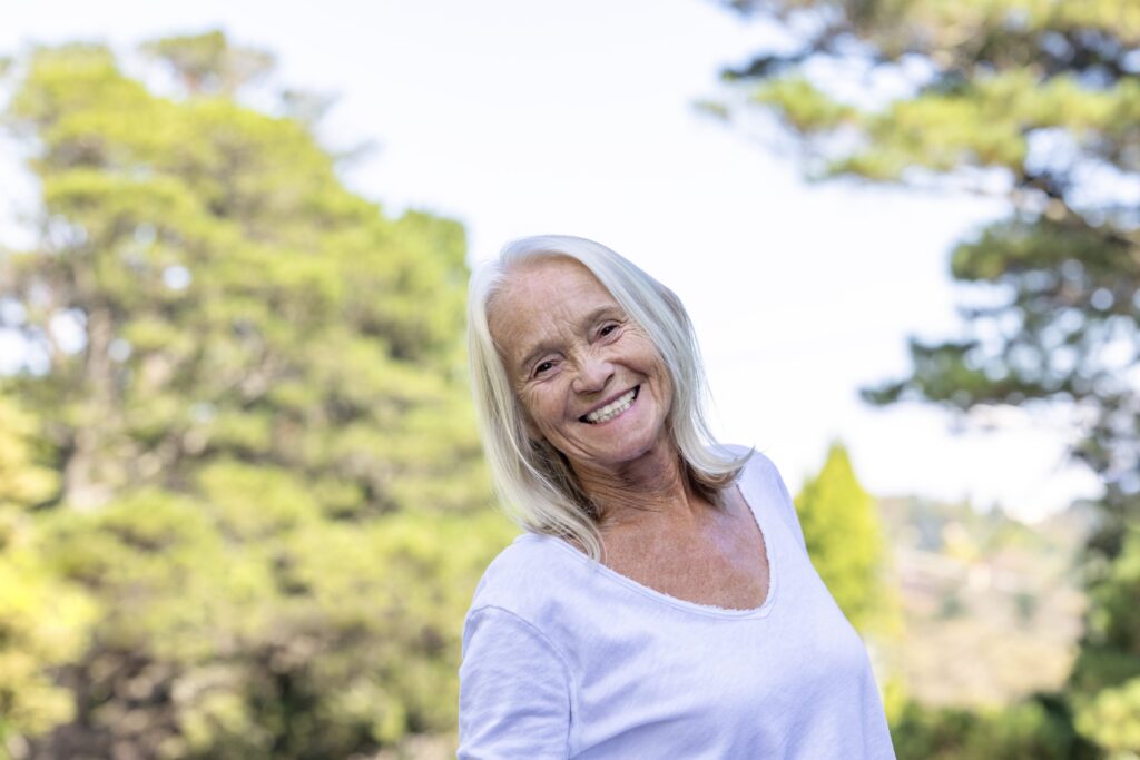 Elderly woman smiling in a sunny field