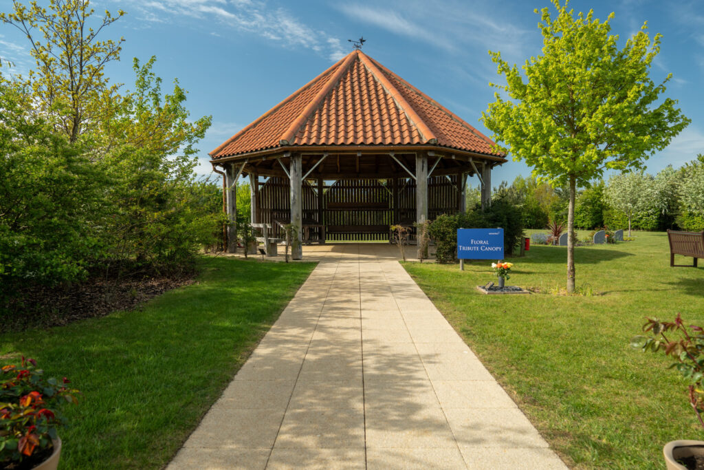 Wooden Floral Tribute Canopy pavilion with a tiled roof beside a garden path