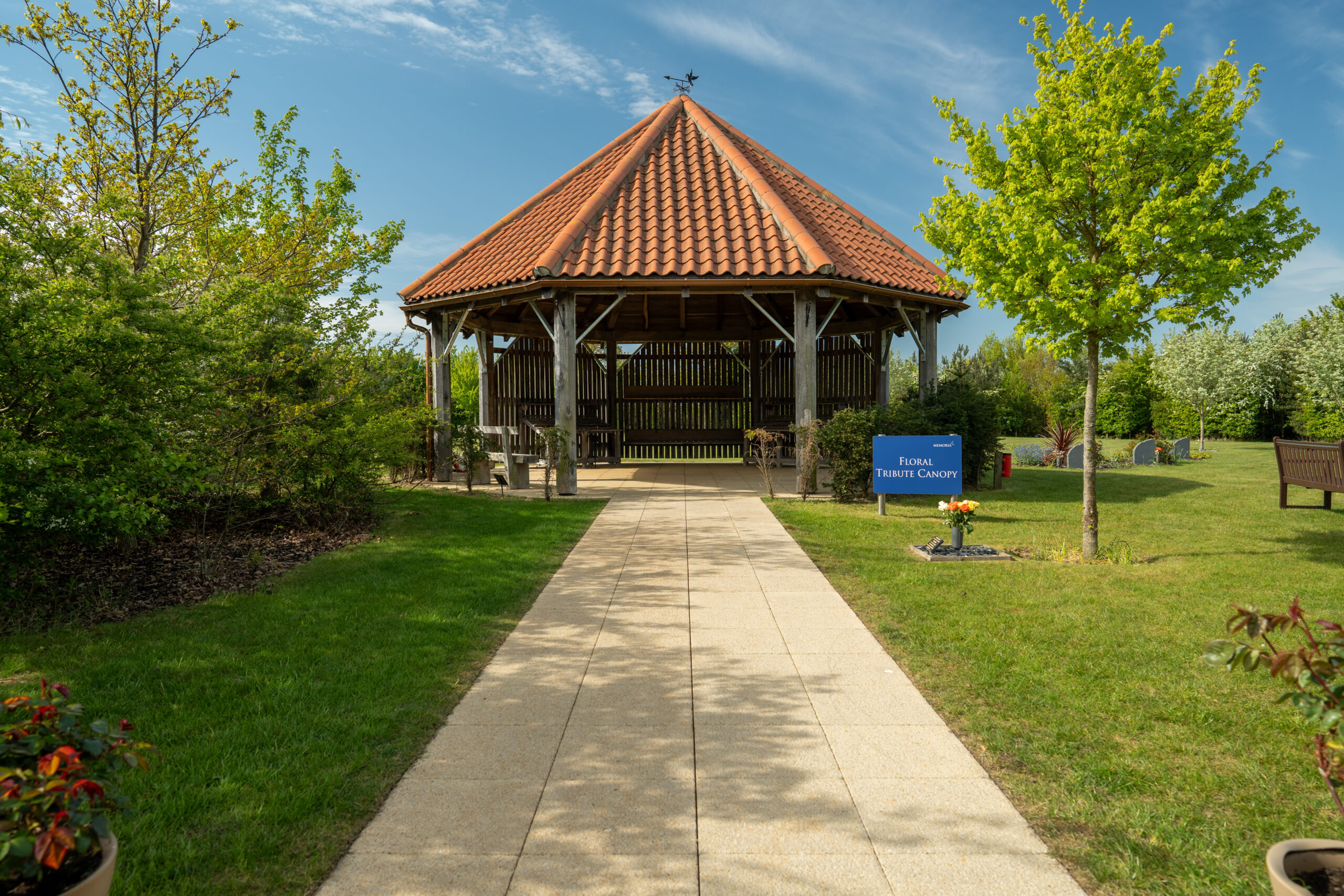 Wooden Floral Tribute Canopy pavilion with a tiled roof beside a garden path